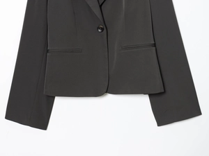 Détail du blazer gris anthracite avec fermeture à bouton unique et texture tissée