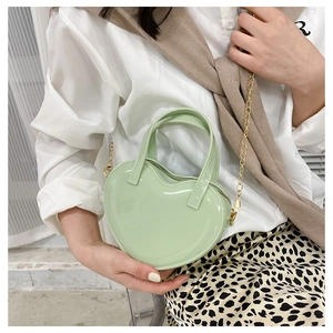 Detail of light green heart-shaped jelly handbag with gold metal handle and chain