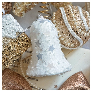 Detail of white bell with silver stars and champagne gold glitter Christmas ornaments