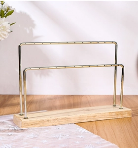 Detail of double-layer gold metal earring display rack with a natural wood base