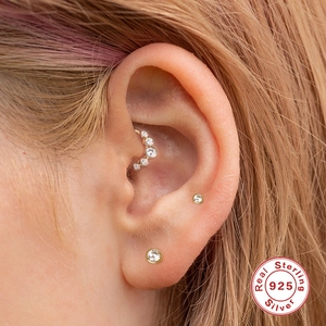 Detailopname van 925 sterling zilveren gouden daith ring en kristallen oorknopjes