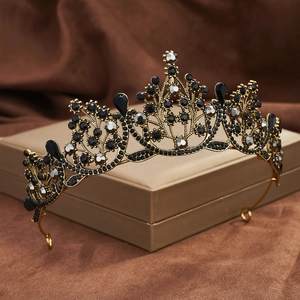 Detailed view of Baroque black crown with waterdrop crystals on golden display stand