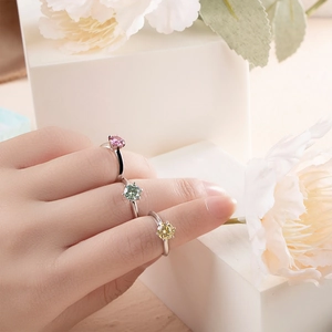 Three elegant S925 silver rings with pink, green, and yellow moissanite on a white base