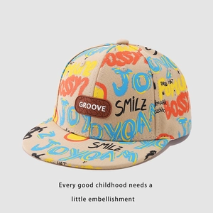 Detail of beige kids hip hop hat with colorful street graffiti and brown leather patch