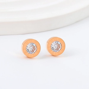 Detailed macro view of rose gold roman numeral stud earrings with central cubic zirconia