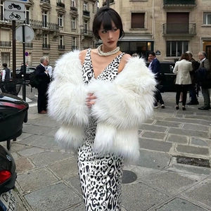 Photo street style d'une robe maxi léopard chic associée à un manteau en fausse fourrure blanche