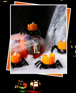 Macro detail of LED spider candle lights with orange wax effect on faux spider web