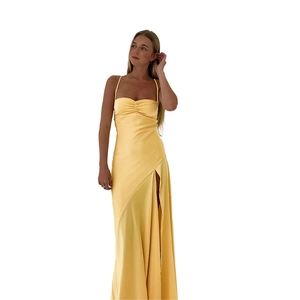 Detail of elegant yellow satin dress featuring spaghetti straps and high side slit design