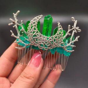 Detailed shot of green crystal hair comb with silver metal branch and hollow patterns