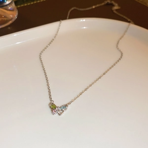 Detailed macro view of butterfly pendant with colorful marquise-cut gems on silver chain