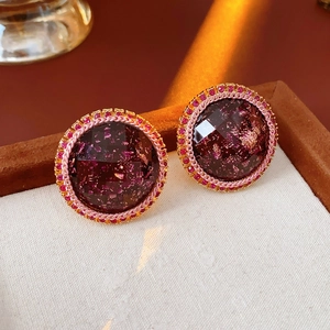 Macro shot of dark purple resin earrings with pink bead accents in a premium jewelry box