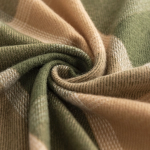 Macro shot of green and beige plaid cashmere fabric texture with fine wool fibers