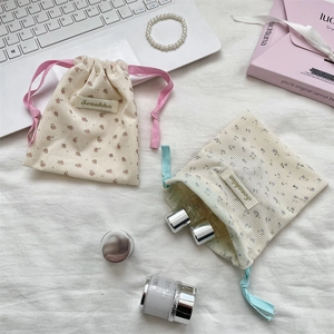 Detail of corduroy floral pouches with drawstring closure for travel cosmetic storage