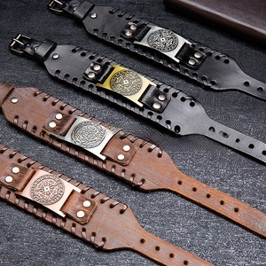 Détail de bracelets en cuir rétro avec plaques en métal de runes vikings et rivets cousus