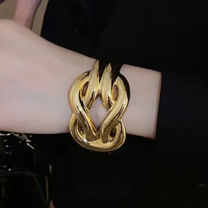 Fashion chunky gold crossover twisted bangle bracelet for women in a modern minimalist style