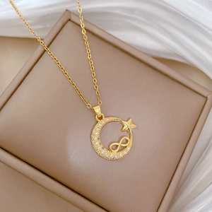 Detail of gold star and moon pendant with sparkling crystals on a sleek titanium chain