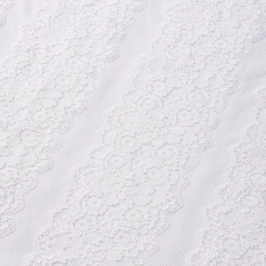 Vue détaillée de la broderie en dentelle florale blanche et texture en maille fine