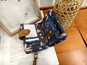 Detail view of navy floral wallet with card slots, ID window and cute bear zipper pull