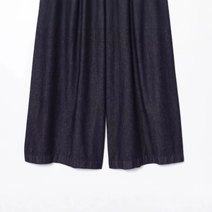 High-waisted wide leg denim jeans in dark blue showing fabric texture and hem detail