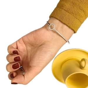 S925 sterling silver bangle with zirconia crystals worn on wrist with yellow knitwear