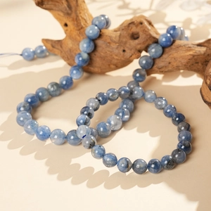 Detailed shot of blue kyanite beaded bracelet displayed on a natural wooden branch
