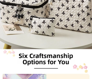 Three-piece white cosmetic bag set with black bow patterns and pearl zipper details