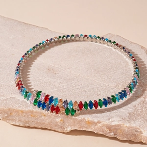 Détail macro de pierres zircons colorées taille marquise sur un collier ras de cou argenté