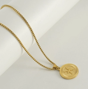 Gros plan du pendentif zodiaque en or 18 carats avec symbole Poissons et chaîne