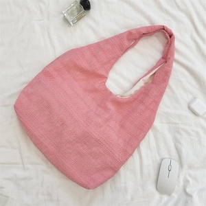 Detail of pink tote bag with unique pleated grid texture and matching shoulder straps