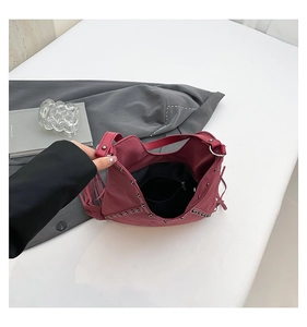 Interior view of wine red fringe tote bag with metal rivets and a zippered pocket