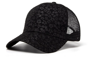 Close-up of black mesh baseball cap featuring 3D floral lace embroidery and mesh panels