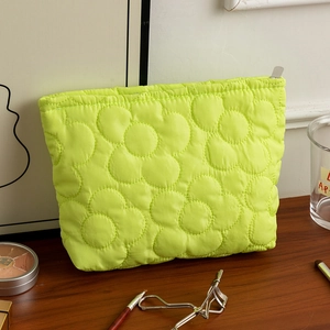 Dettaglio della trapuntatura floreale sulla borsa cosmetica portatile giallo neon