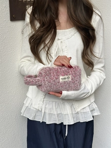 Close-up of pink leopard plush makeup bag with soft texture and side handle detail