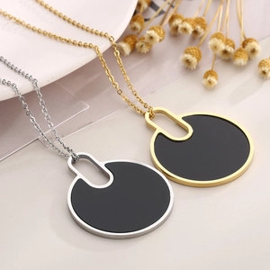 Minimalist gold and silver titanium necklaces with large round black pendants in a set