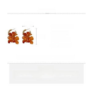 Detail view of retro amber floral earrings with golden alloy accents and silver pins