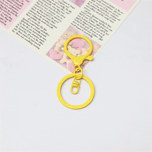 Detail of bright yellow lacquered metal lobster clasp and round keyring accessories