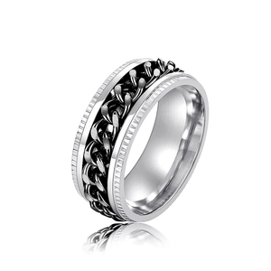 Macro detail of silver stainless steel ring with spinning black cuban chain texture
