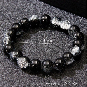 Fashionable men's beaded bracelet with black and white glass beads on a dark background