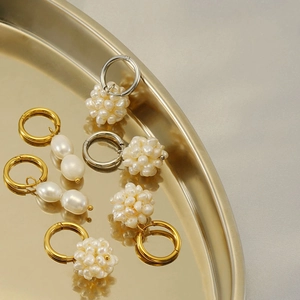 Détails de boucles d'oreilles en perles dorées et argentées sur un plateau doré