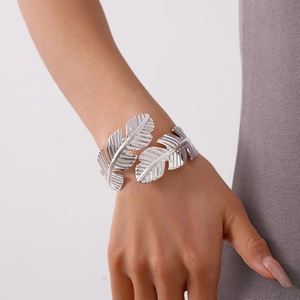 Close-up of silver leaf feather cuff bracelet with detailed texture on model's wrist