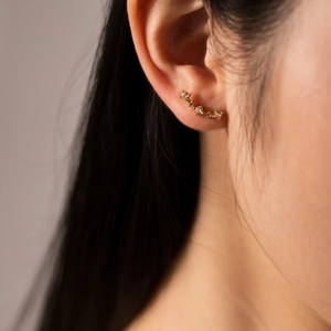 Detail of s925 silver ear crawler with sparkling zircons worn on the earlobe