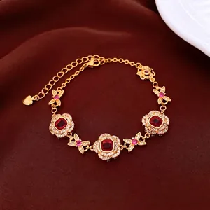 24K gold plated flower bracelet with red stones and butterfly links on silk fabric
