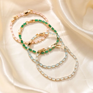 Colorful glass bead bracelets in pink green and blue on luxury champagne silk