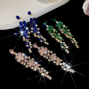 Macro shot of elegant floral tassel earrings in blue green and pink sparkling crystals