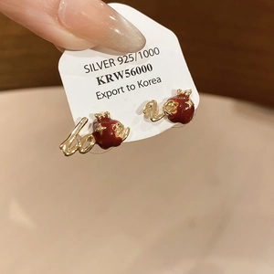 Detailed close-up of 18k gold plated red apple stud earrings with love lettering