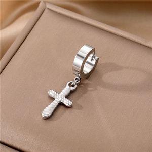 Detailed macro view of silver stainless steel cross earring with textured relief design