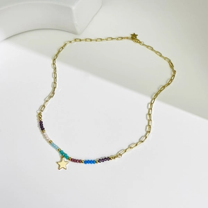 Collier de perles colorées avec pendentif étoile dorée et chaîne sur fond blanc