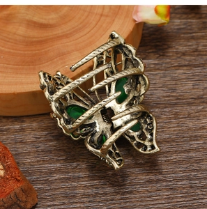 Detailed macro shot of vintage bronze butterfly hair claw clip with green gemstones