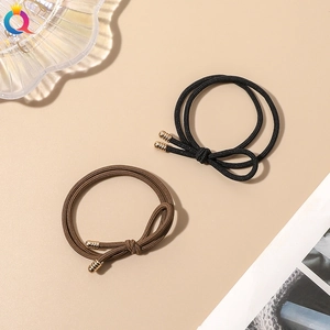 Close-up of black and brown braided elastic hair ties with gold metal clasps