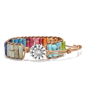 Dettaglio del bracciale bohémien in pelle intrecciata con perline colorate e bottone a girasole